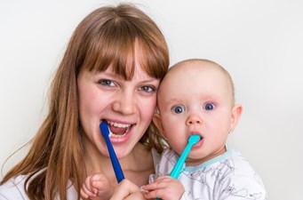 child and mother brushing teeth