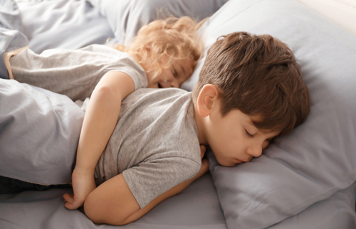 toddler and child sleeping next to eachother