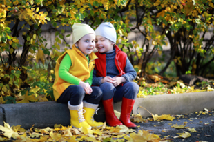 two children sitting on a curb
